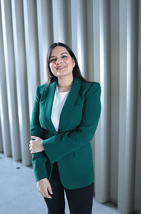 Portrait of Karnica Karda in a formal and stylish green blazer.