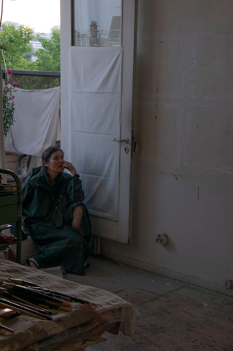 Dans l'atelier, la peintre regarde son oeuvre