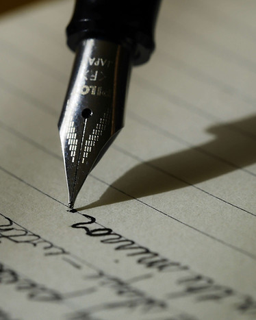 Fountain pen writing on paper during document review