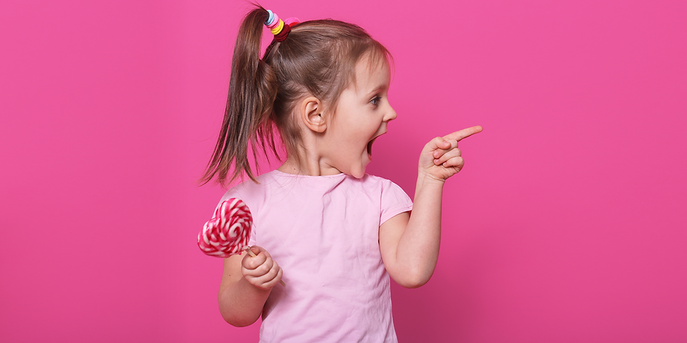 ילדה קטנה מחזיקה סוכריה על מקל ומצביעה שמאלה