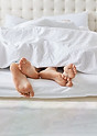 horizontal-shot-feet-couple-white-bedclothes-bed-bedroom-1.jpg