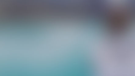 vrouw uitkijkend op prachtig blauw meer, overpeinzend over leven, voorafgaand aan lange reis.