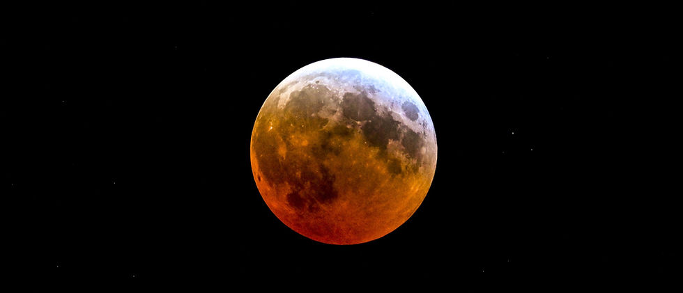 Wide-angle view of a partially eclipsed Moon above a quiet open field.