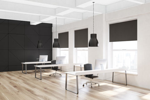 large office with black motorized roller shades