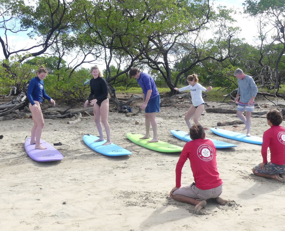 Group surf lesson learning to pop-up