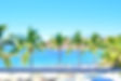 Playa en zona montañosa con palmeras y lanchas