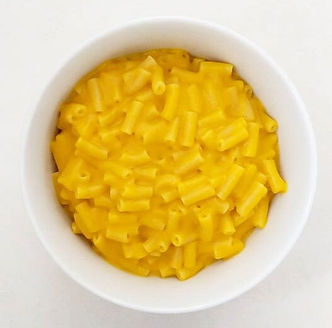 A bowl of creamy macaroni and cheese, topped with a sprinkle of herbs for garnish, emphasizing the rich, creamy texture.