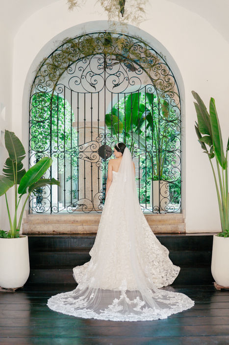 Espalda de novia en elegante vestido de boda ante puerta de hierro.