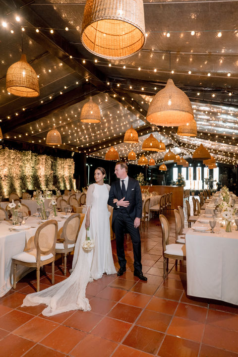 Bride and groom walking down the aisle at an elegantly decorated wedding reception.