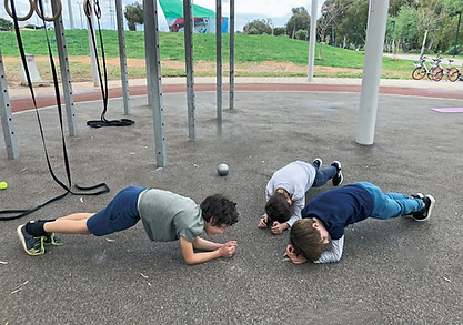  ילדים מתאמנים על הקרקע בחוץ 