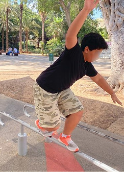 ילד מתאמן בחוץ בתרגיל שיווי משקל .