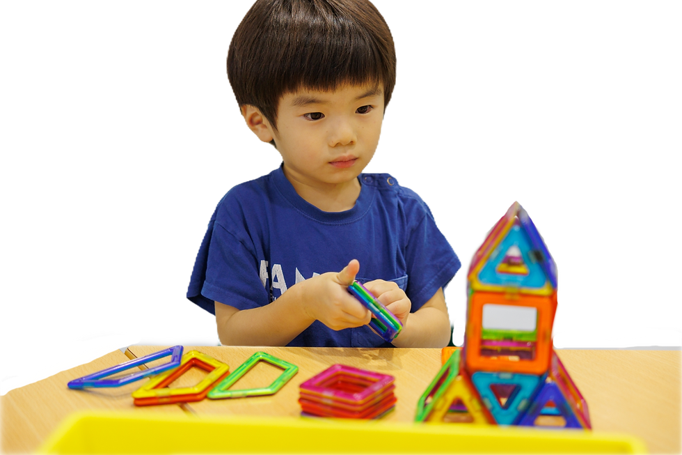 男の子がカラフルな磁石ブロックで遊んでいる。集中して組み立てている様子。