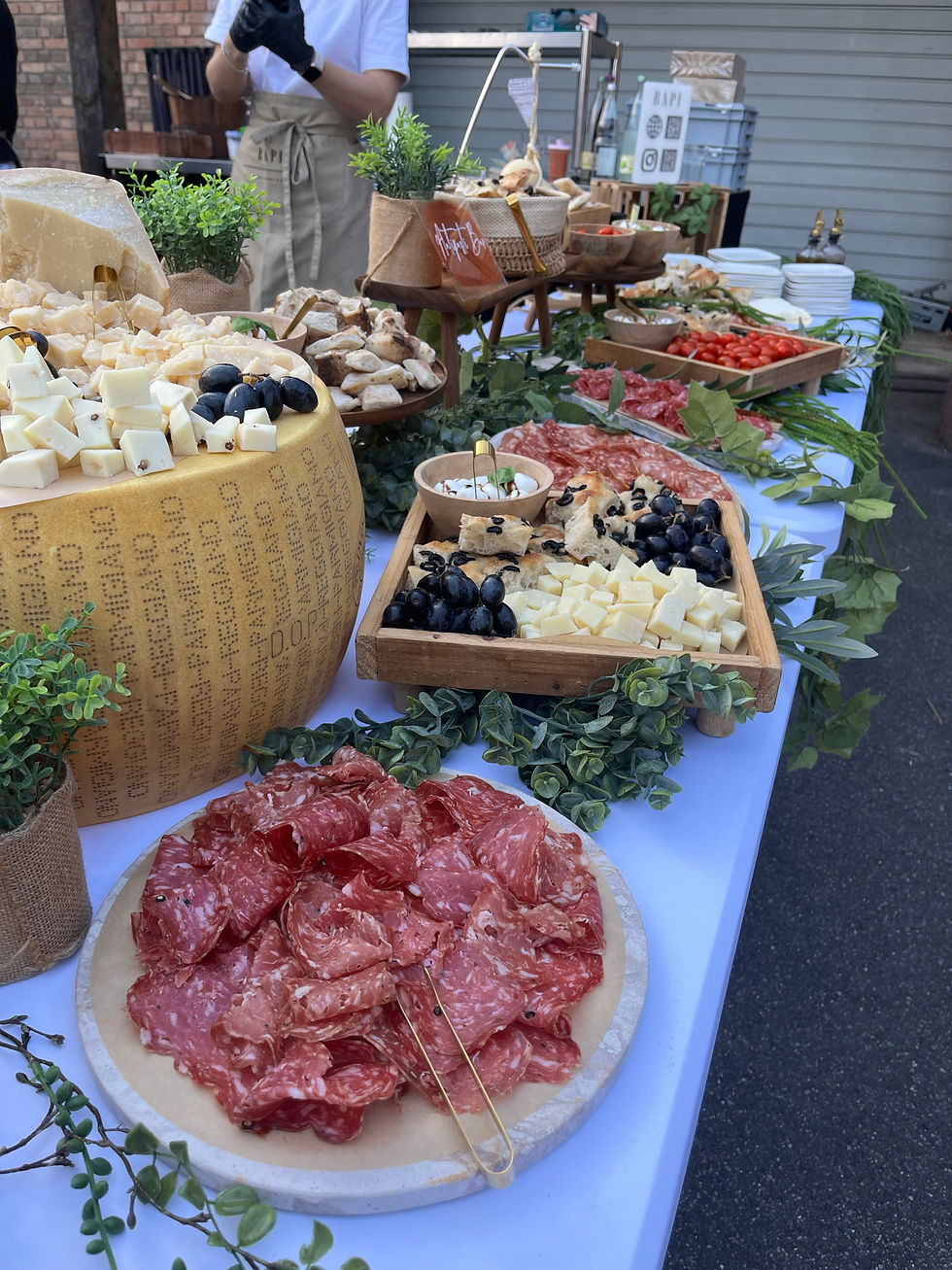 Komplett aufgebautes italienisches Drop-Off Buffet auf Eventtischen im Außenbereich.