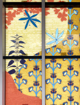 Platform of a light rail station in Kent, WA. The glass design has vibrantly colored edible plants.