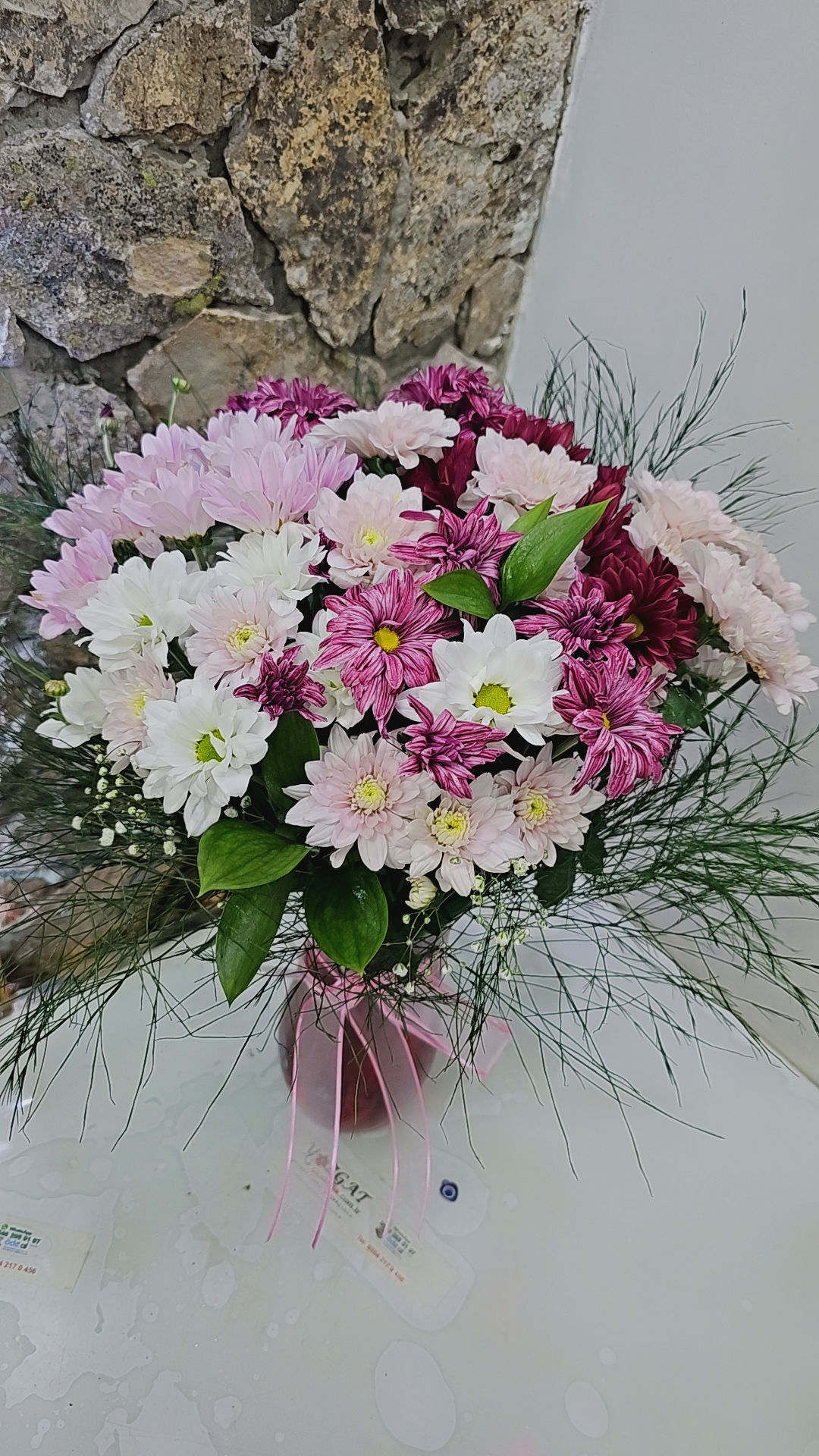 Kırmızı vazoda renkli papatyalar