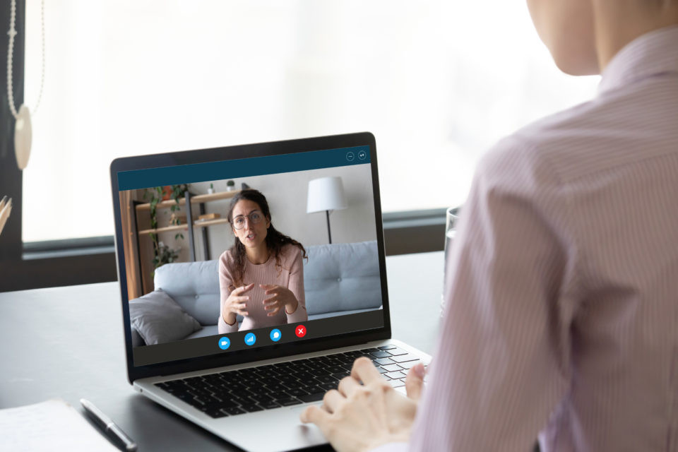 Person is sitting at desk while takes part in telehealth session at Catalyss Counseling in Colorado. Our caring therapists provide you with solutions to your treatment needs doing online therapy and online counseling in the Denver CO area 80209 and 80210