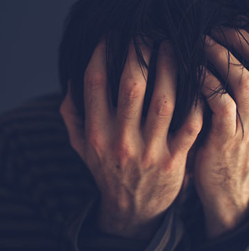 Man with head in hands dealing with the loss and grief of a loved one in Englewood, CO. He could use a skilled bereavement therapist for grief and loss therapy in Denver, CO at Catalyss Counseling 80209 and 80210