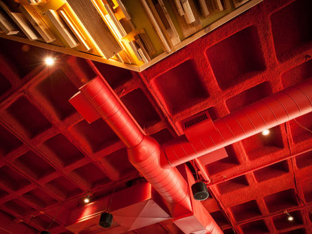 Se discute las ventajas del material absorbente de sonido proyectado sobre los colgados o anclados al techo, bajo el punto de vista de costos, estética y eficiencia