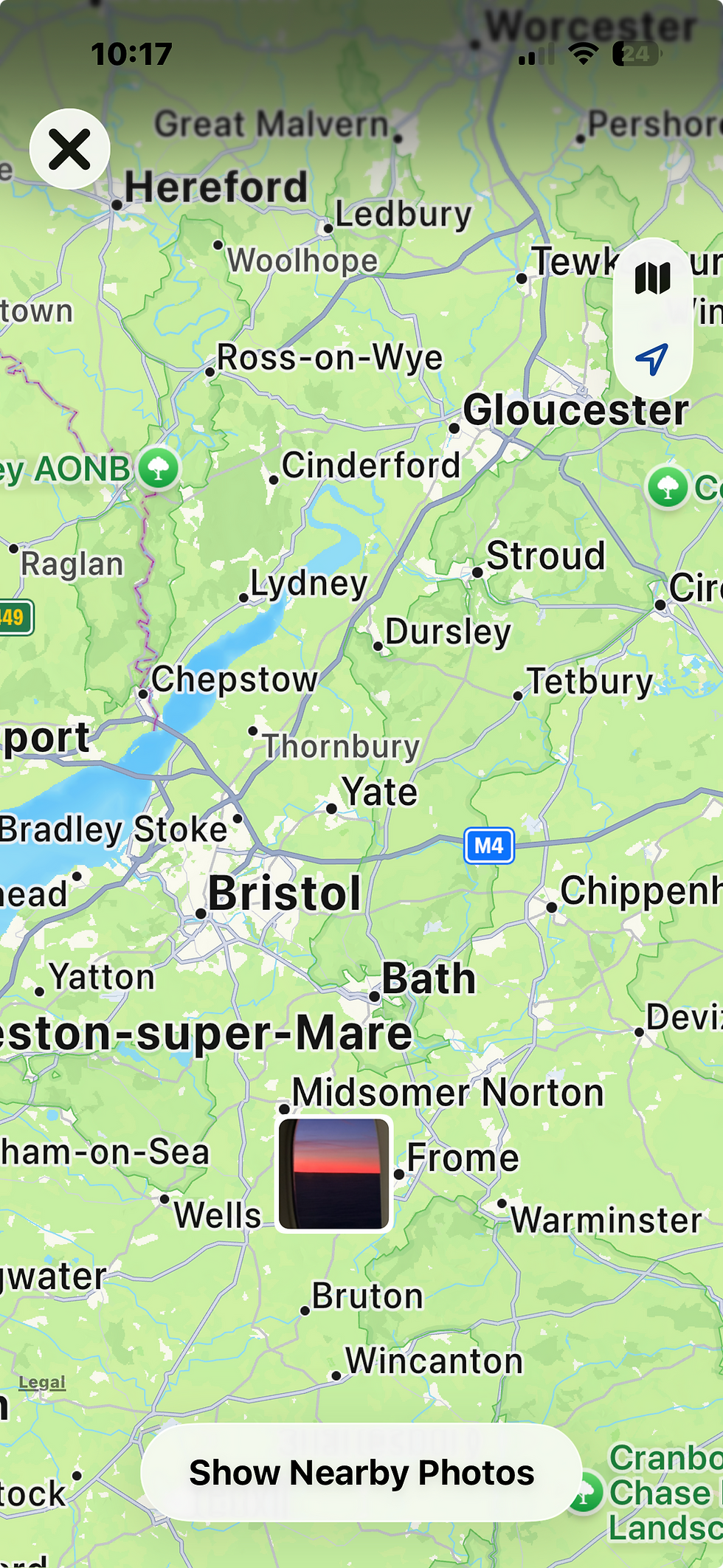 Map showing areas around Bristol with towns like Gloucester and Bath. A sunrise photo icon at the bottom, button says Show Nearby Photos.