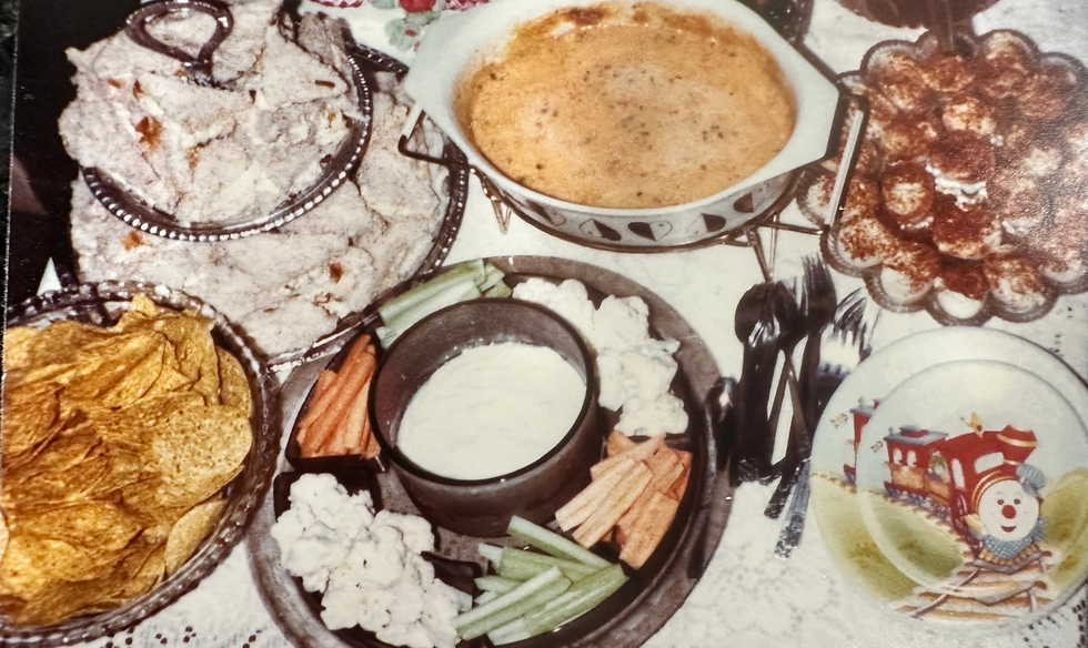 Assorted snacks on a table: chips, dip, veggies, and deviled eggs. A plate features a cartoon train design, creating a festive mood.