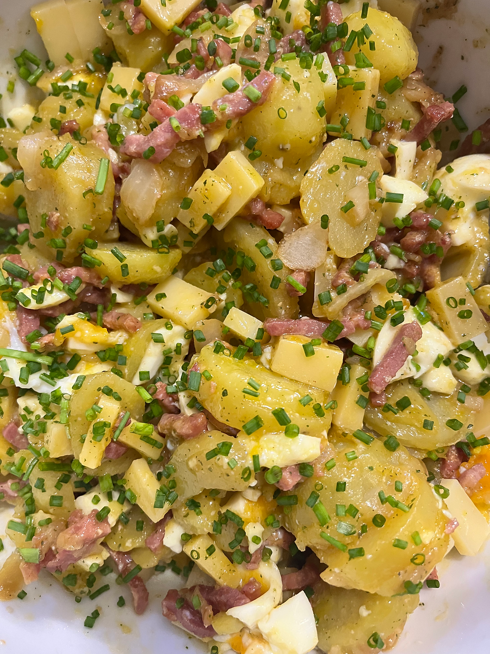 Salade pomme de terre, lardons, oignons, comté, œuf coulant