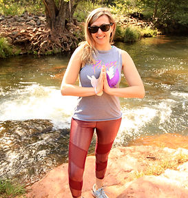 A woman smiling doing yoga in Sedona outdoors with Vita Pura Yoga