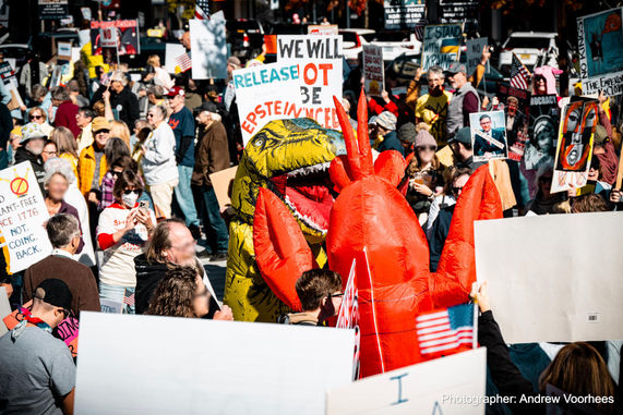 A crowd of protesters including some dressed in costumes.