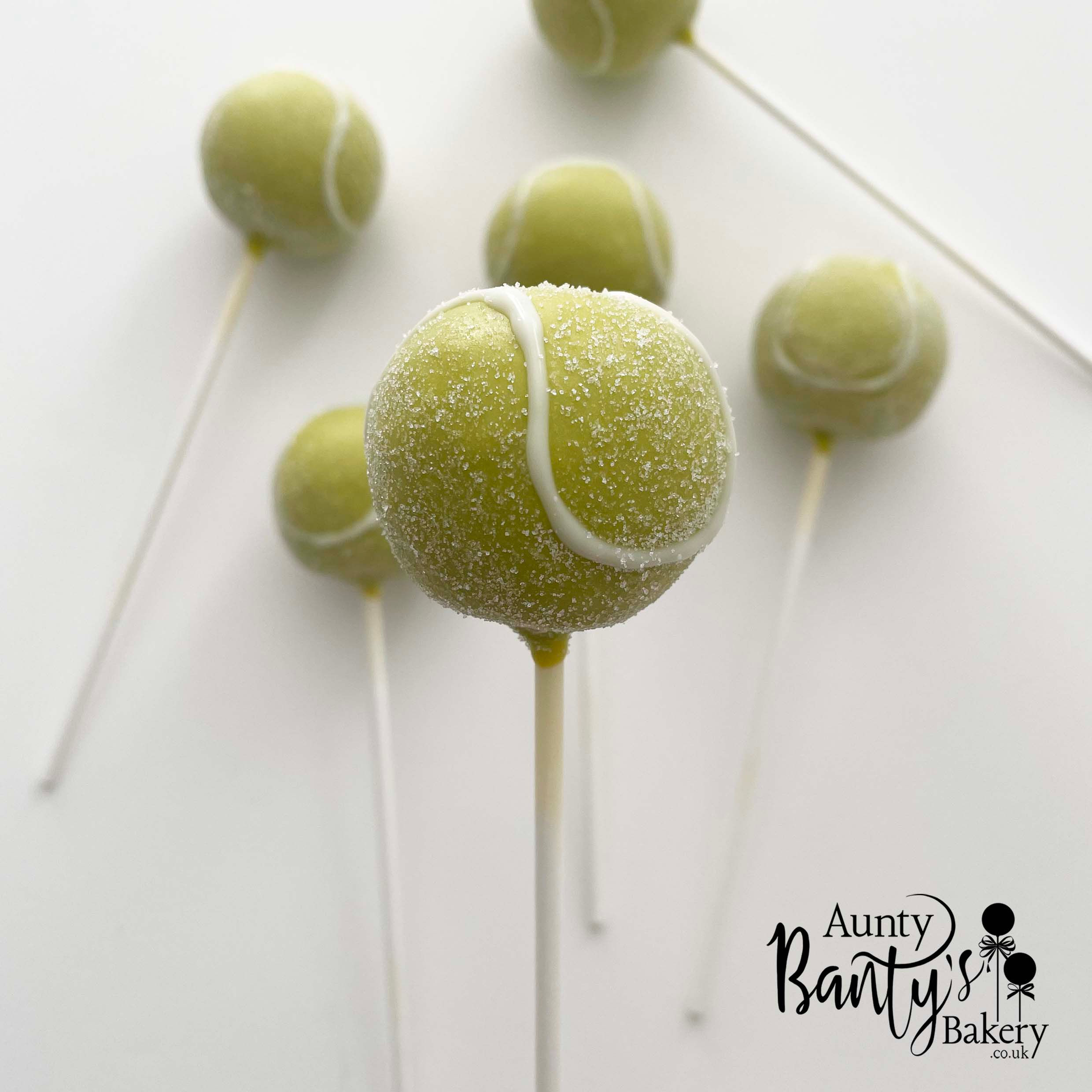 Close up of Tennis ball cake pops coated in a vibrant lime green-yellow chocolate, with the iconic white tennis-ball pattern.