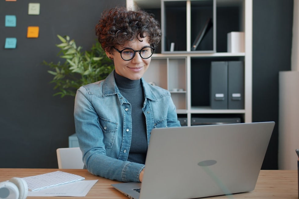 Woman working on a laptop at a desk.