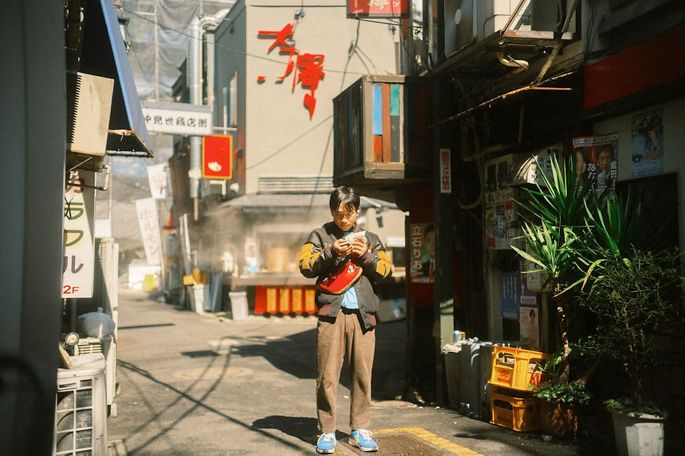 Person stands in an alleyway looking at their phone.