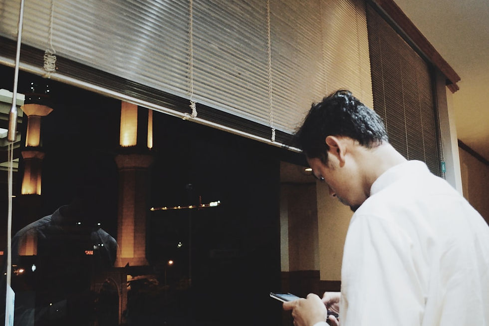 man using smartphone while face window