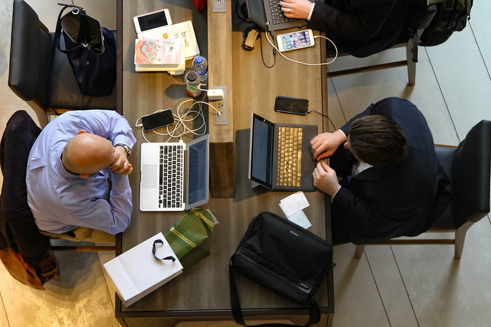 man sitting on chair in front of laptop and man