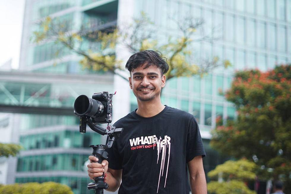 Young man holding a camera stabilizer outdoors.