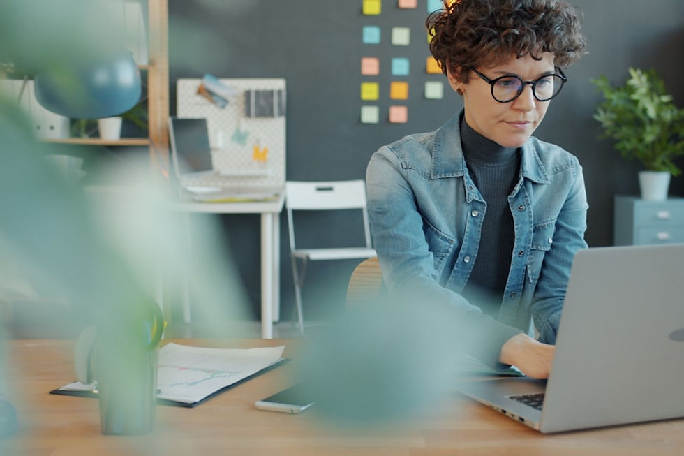 A woman with curly hair working on a laptop.