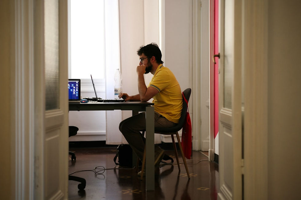 man siting facing laptop computer