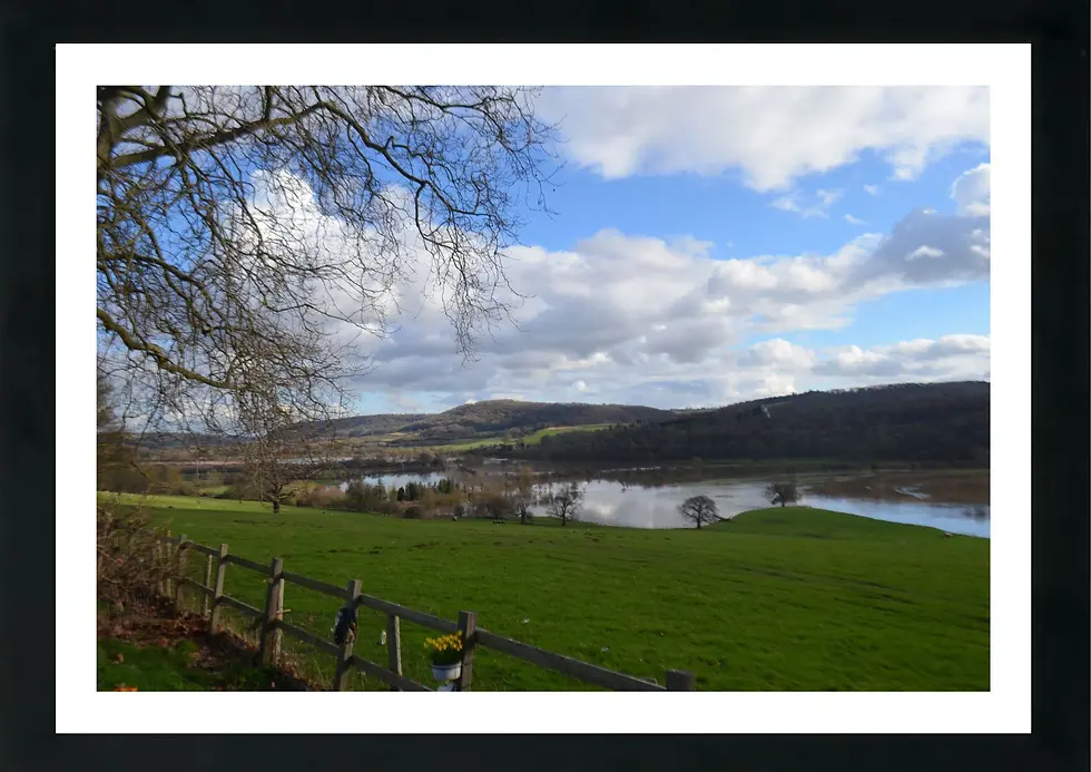 Thumbnail: Landscape Print with black frame - A calm river glides through the Shropshire valley beneath a sky of soft spring clouds.