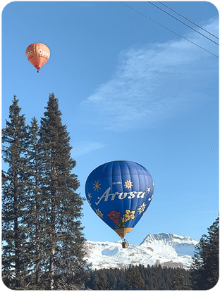 Heissluftballon über verschneiter Landschaft in Arosa – Ballonfahrt Graubünden Schweiz erleben und buchen