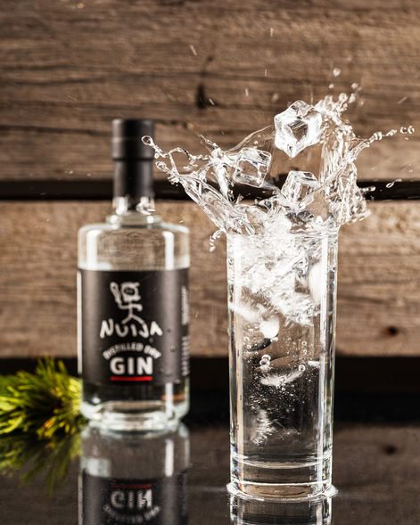 Nuija Gin kirkaspullo- Tuotekuva Gini pullosta ja drinkki lasista