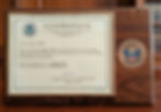 Customs Broker License certificate with U.S. Homeland Security logos, framed on a wooden plaque. Issued July 3, 2025, in Washington, D.C.