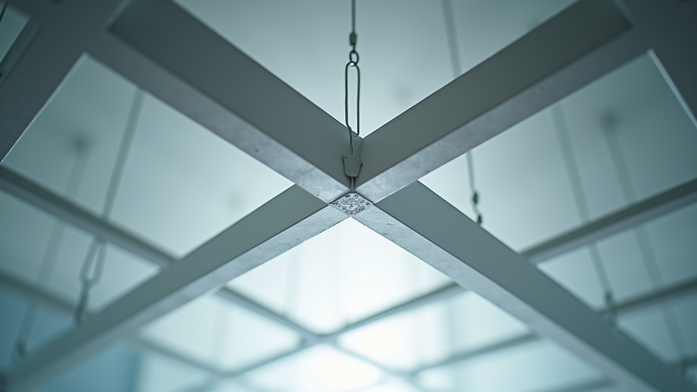 Close-up view of suspended ceiling grid with main runners and cross tees connected