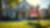 Eye-level view of a suburban house with a "For Sale" sign in the front yard