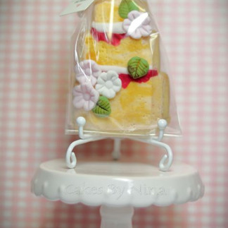 White stand with wedding cake cookie with sugar flowers
