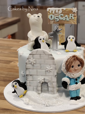 Birthday cake with polar bear, penguins, igloo, and Oscar sign.