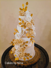 A celebration of timeless sophistication, all delivered and set up at Rivervale Barn - Golden Elegance is a luxurious four-tier wedding cake that combines classic ivory with shimmering champagne and gold accents to create an unforgettable centrepiece.