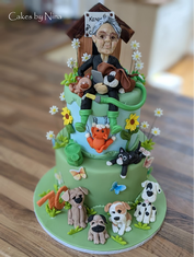 Cake decorated with a woman gardener and several dog figures