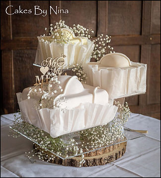 One of our bespoke wedding cakes giant French Fancies but in very subtle pastle colours displayed on our beautiful acrylic stand all set up at Great Fosters Venue