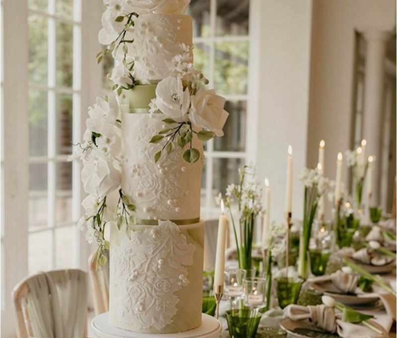 Emily Sage luxury wedding cake with soft sage green detailing and delicate handcrafted sugar flowers, an elegant bespoke wedding cake by Cakes by Nina for stylish Surrey weddings.