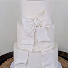 White wedding cake with an large statement sugar white bow