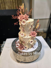Cream ganache background two tier wedding cake with edible pearls and sugar flowers in dusky pink and dried foliage - Frimley Hall Hotel