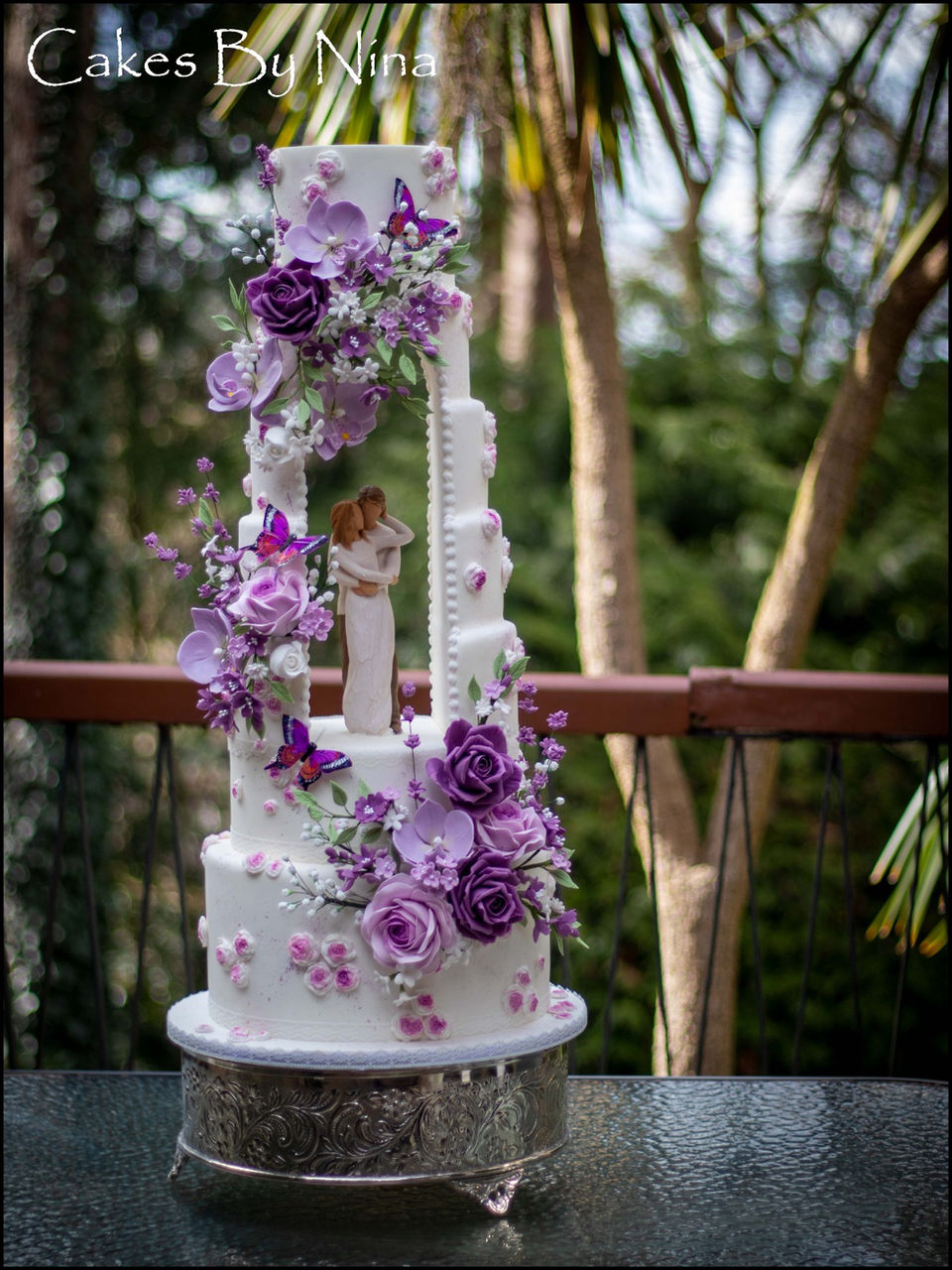 Luxury wedding cake Surrey, Hampshire and Berkshire - bespoke sugar flower wedding cake. An award winning cake design in Surrey. Talking point wedding cake, with open arch, truly stunning wedding cake, romantic wedding cake, lots of sugar flowers in beautiful lilac and purples, cakes by nina, luxury wedding cakes, wedding cakes